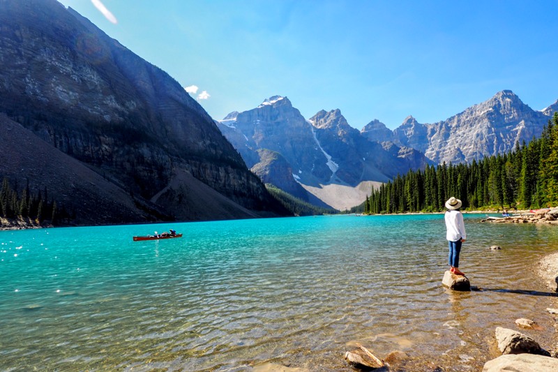 a girl standing on a rock at Moraine Lake, Banff National Park